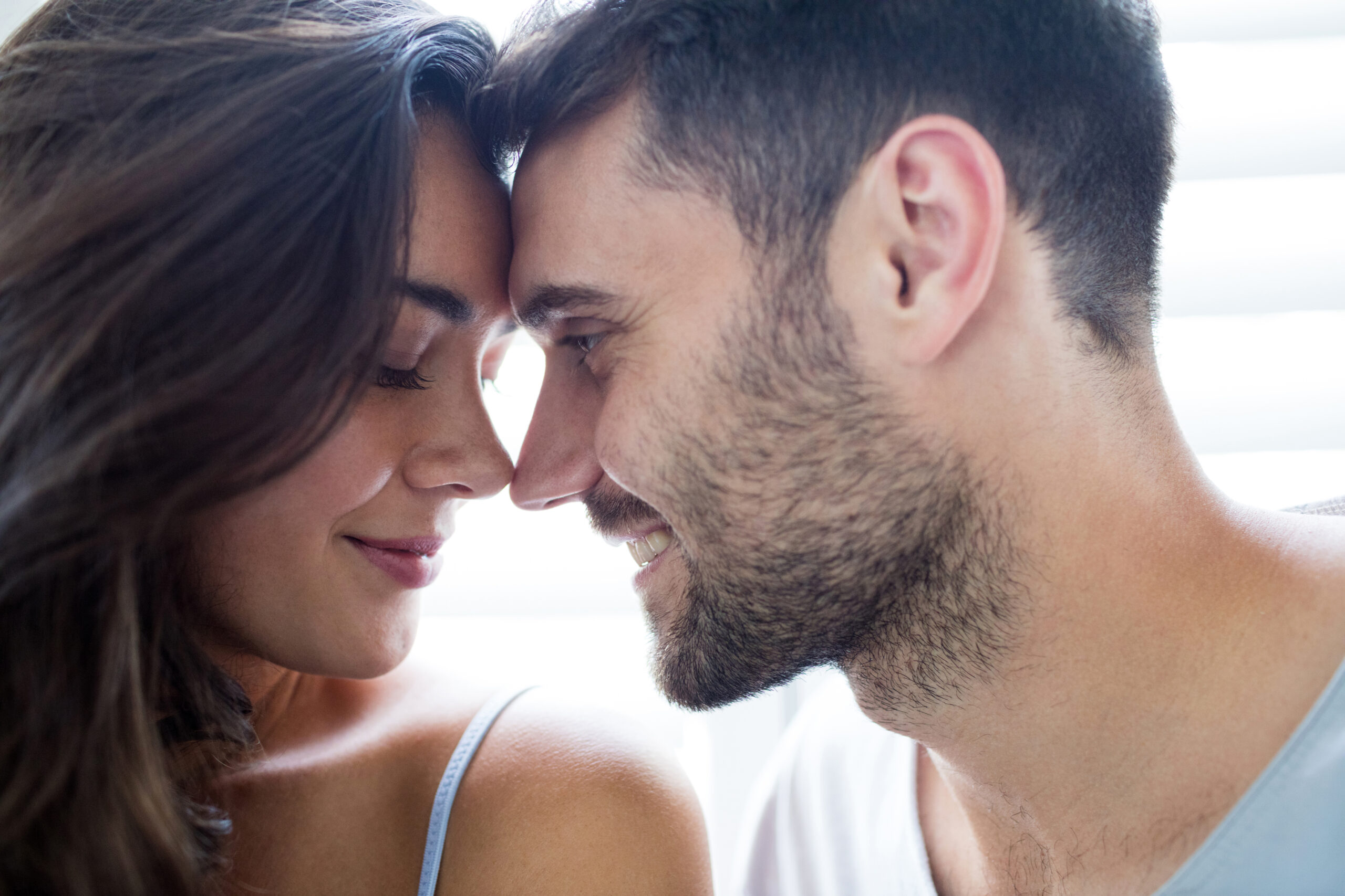 Young couple romancing in bedroom at home